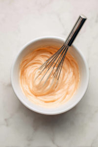 In a small bowl, whisk together the mayonnaise, Greek yogurt, sriracha, lime juice, garlic powder, and salt until smooth